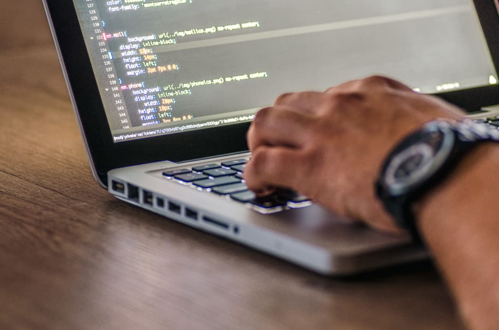 Développeur web tapant une ligne de commande sur son ordinateur